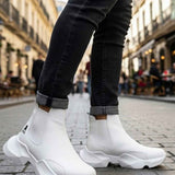 White ankle boots with chunky tread sole, stitched upper, worn with dark jeans cuffs