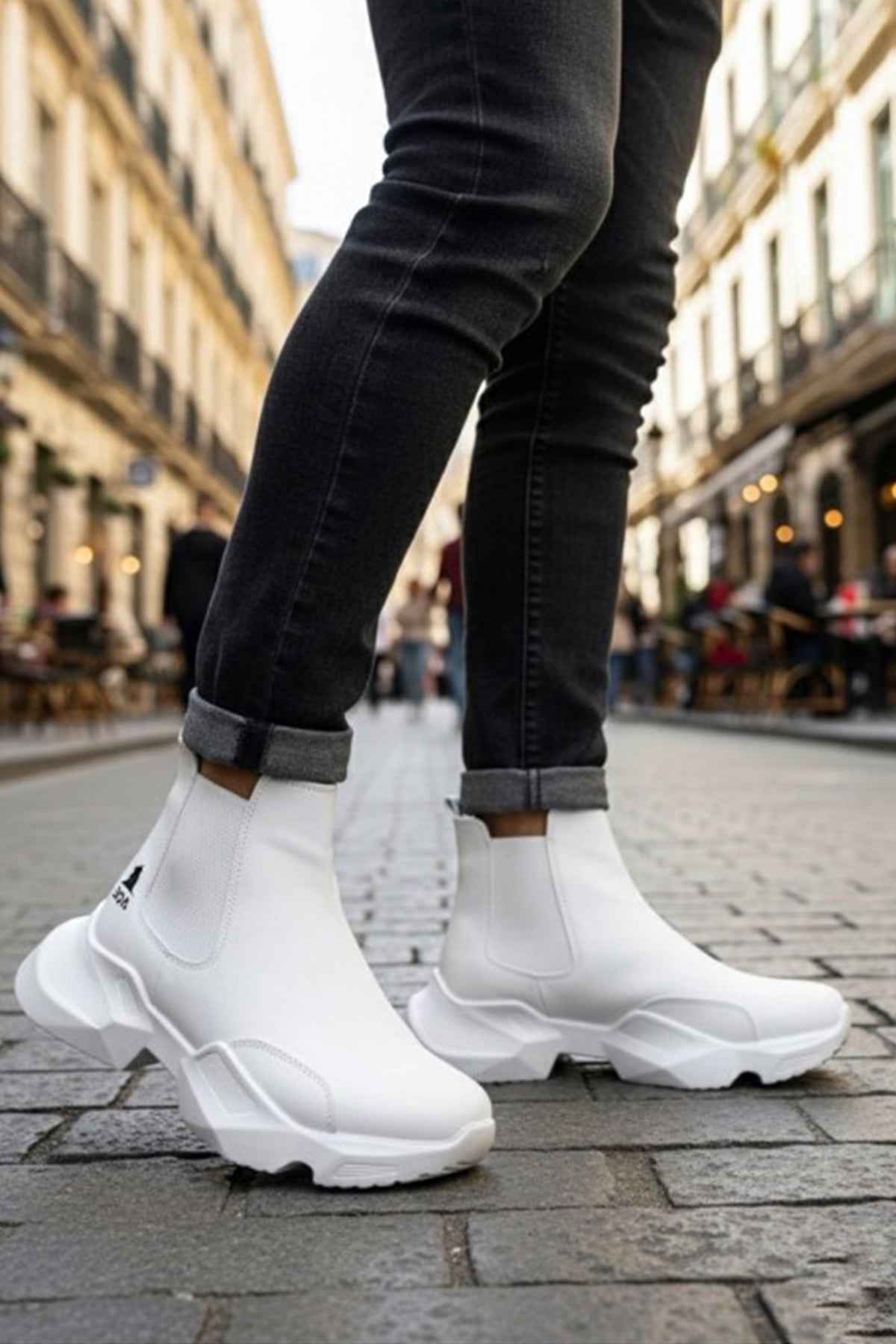 White ankle boots with chunky tread sole, stitched upper, worn with dark jeans cuffs