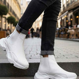 White ankle boots with chunky sole and elastic side panels; dark jeans cuffs above