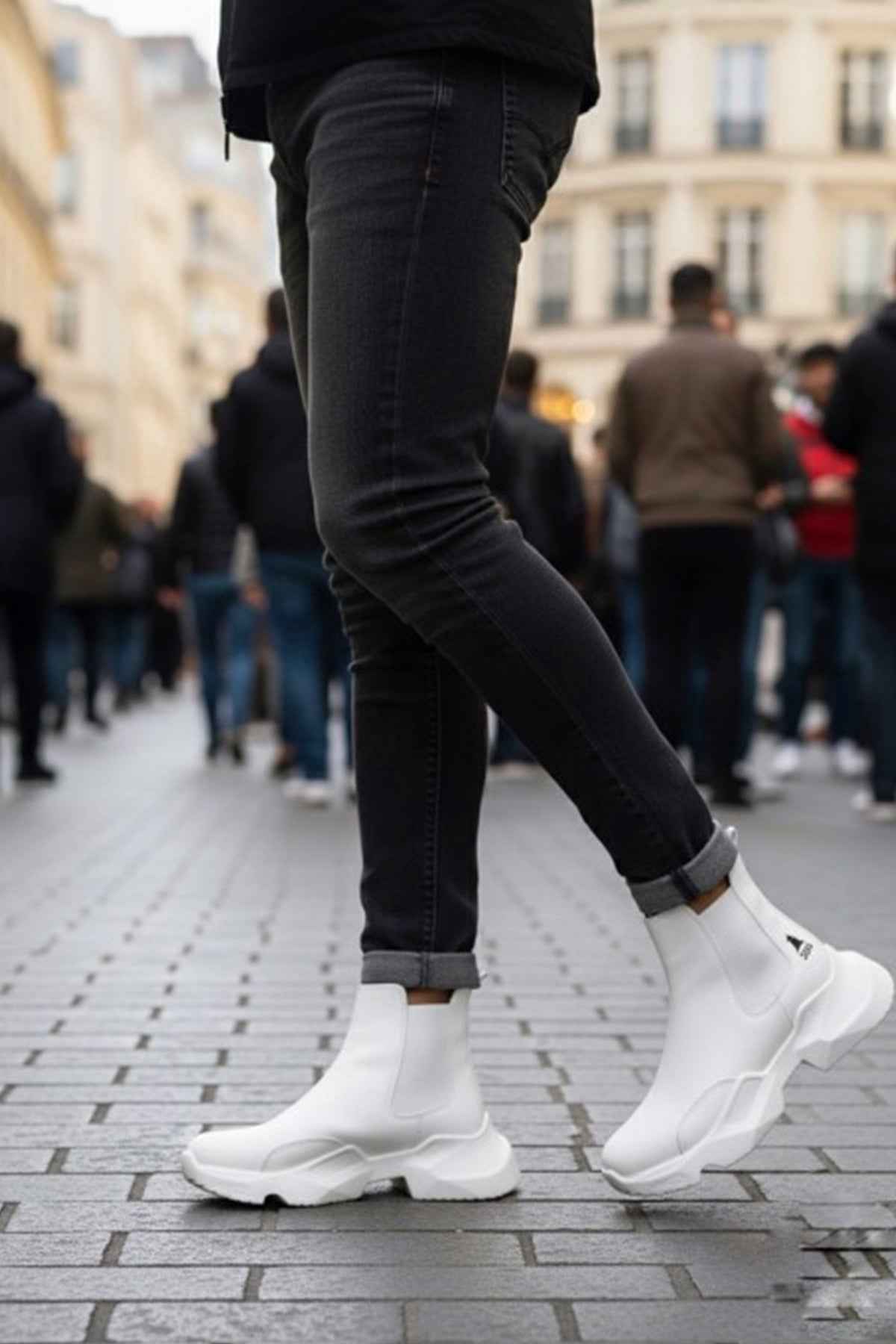 White ankle boots with thick tread sole and low shaft; dark jeans and socks visible