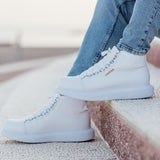 White lace-up boots with visible stitching and textured rubber sole