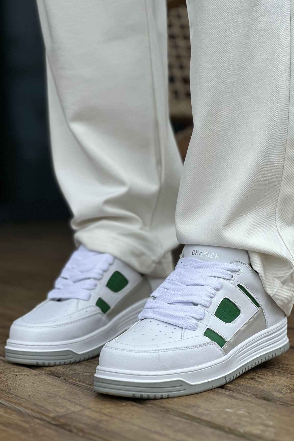 Men's white green low-top sneakers, front view with green side panels and lace-up