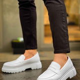 White loafers worn with dark pants, slip-on style with strap and cushioned sole