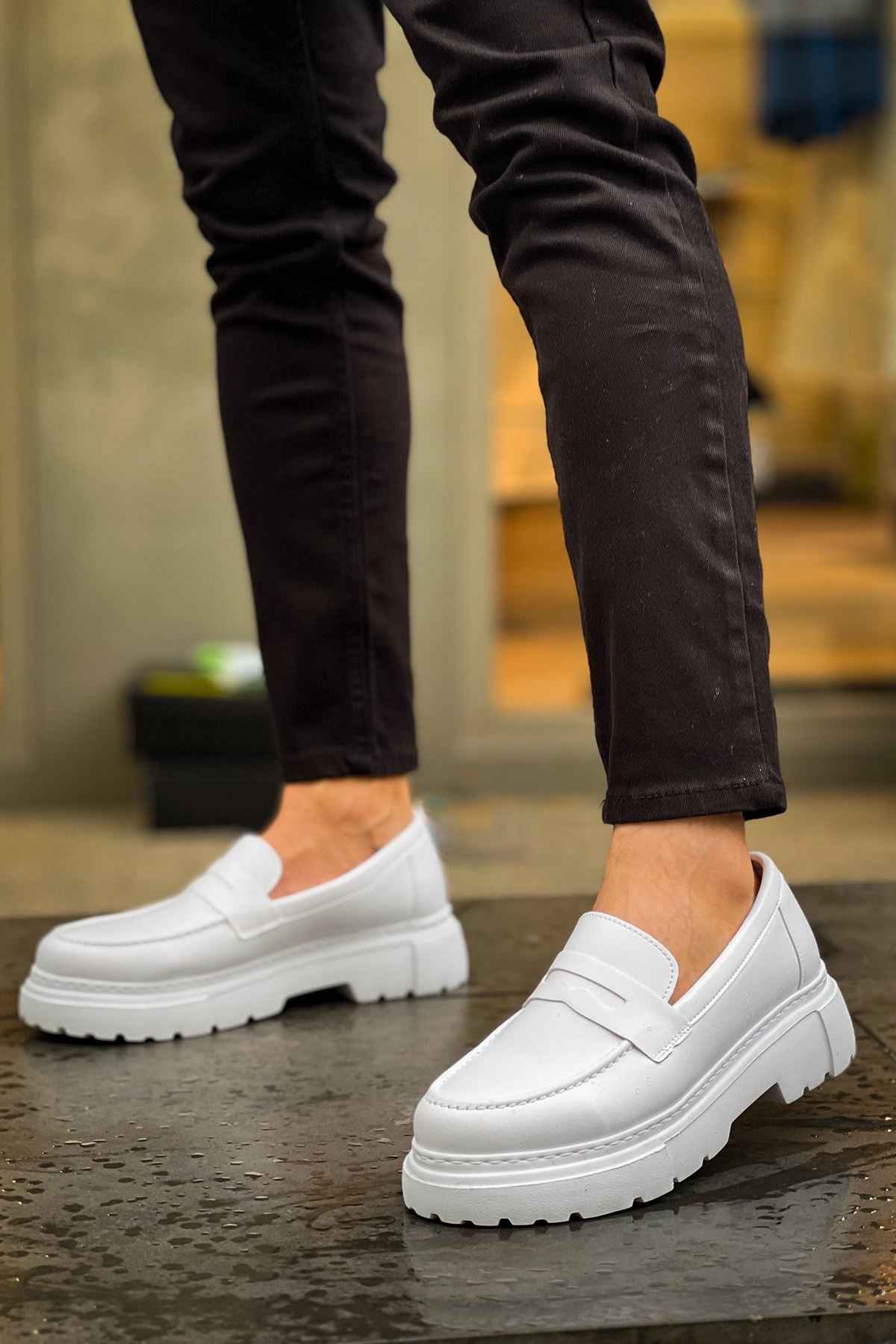 White loafers worn with dark pants, slip-on style with strap and cushioned sole