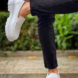 White loafers being slipped on, strap detail and chunky tread sole