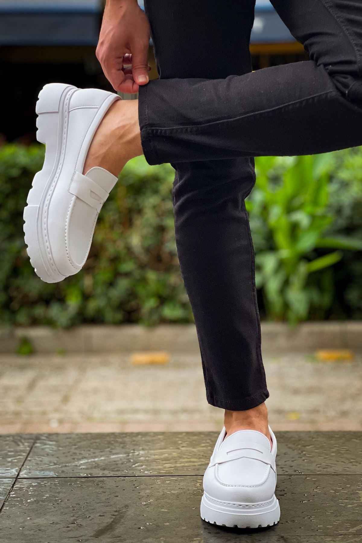 White loafers being slipped on, strap detail and chunky tread sole