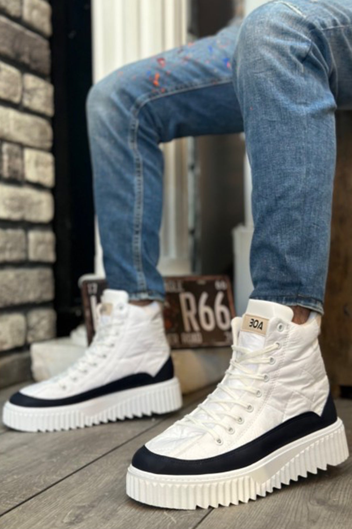 White lace-up high boots with navy trim, thick sole, and textured tread