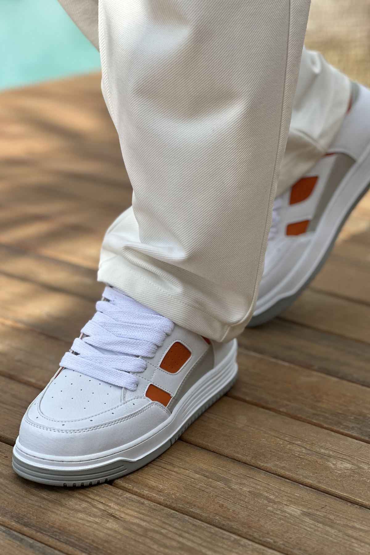 Men's white sneakers with orange side panels, lace-up design and gray rubber sole