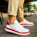 White lace-up sneakers with red trim and red heel accent