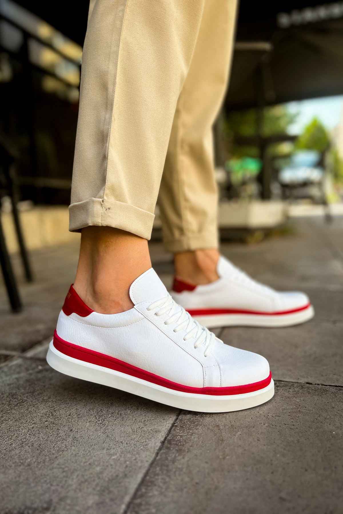 White lace-up sneakers with red trim and red heel accent