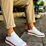 White lace-up sneakers with red outsole edge and red side stripe