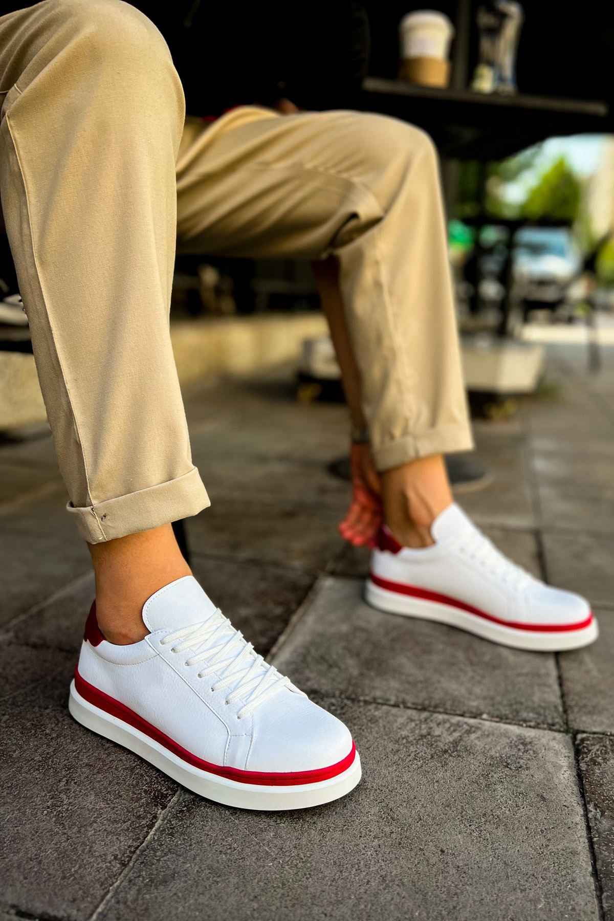 White lace-up sneakers with red outsole edge and red side stripe