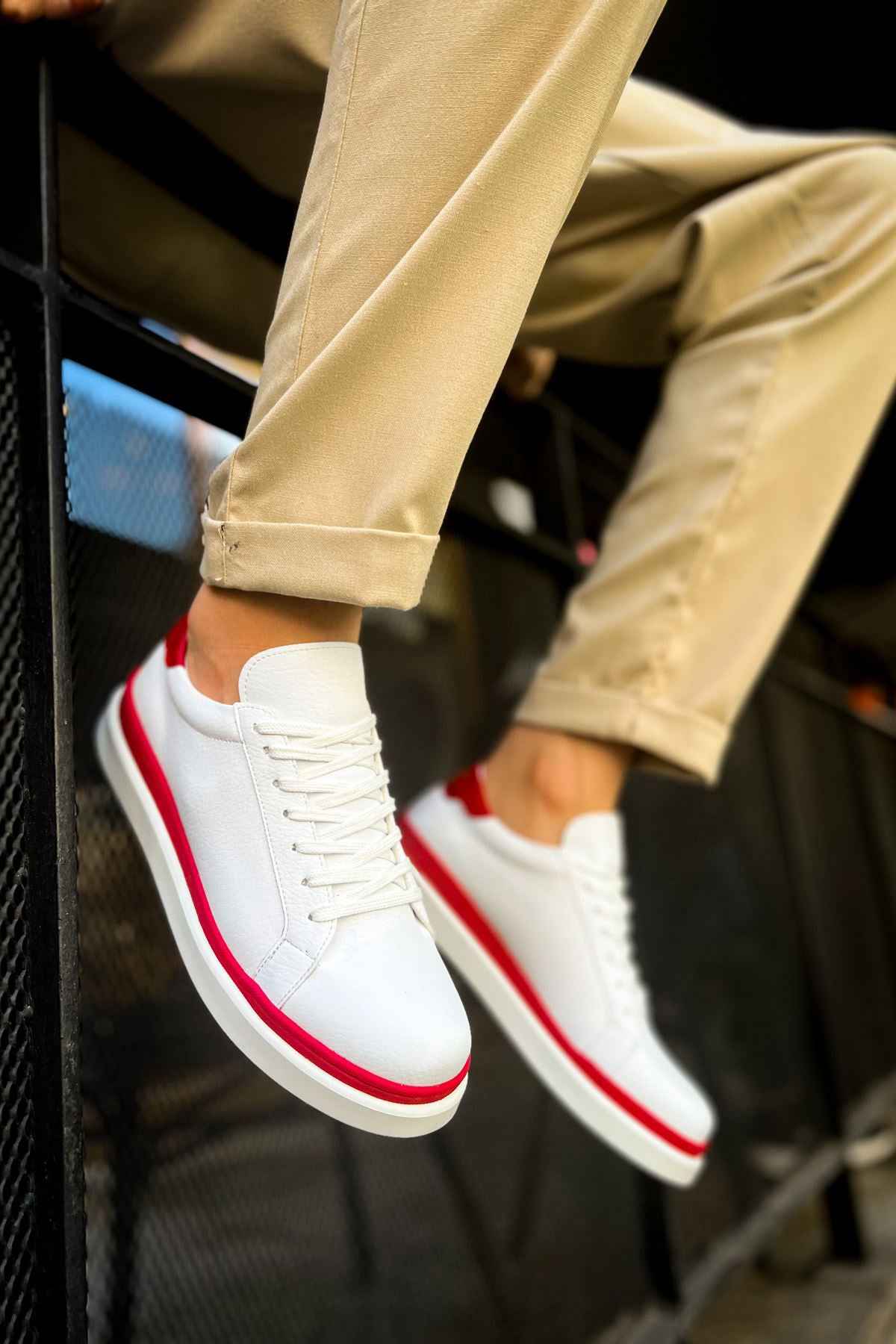 White low-top lace-up sneakers with red piping and red heel trim