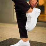 Men's white leather-style lace-up shoes with chunky outsole, on-foot side profile