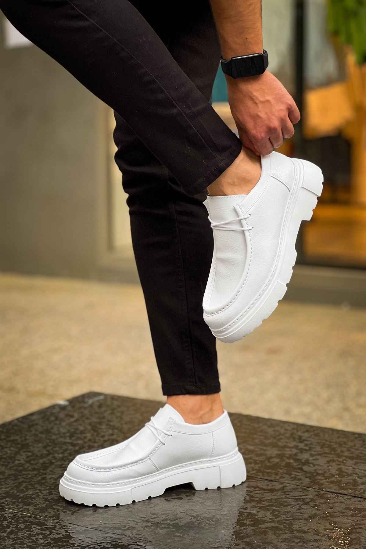 Men's white leather-style lace-up shoes with chunky outsole, on-foot side profile