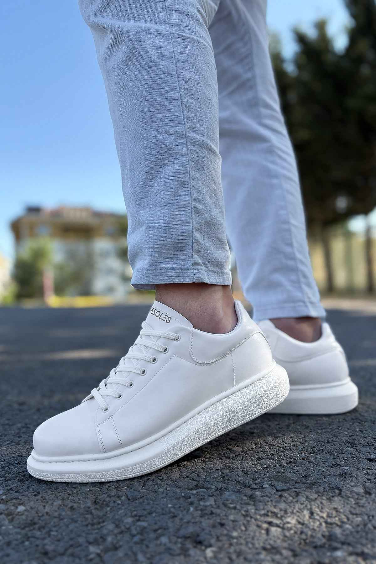 White low-top lace-up sneakers, side view, clean leather upper