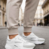 White chunky sneakers with lace-up front and textured rubber sole.