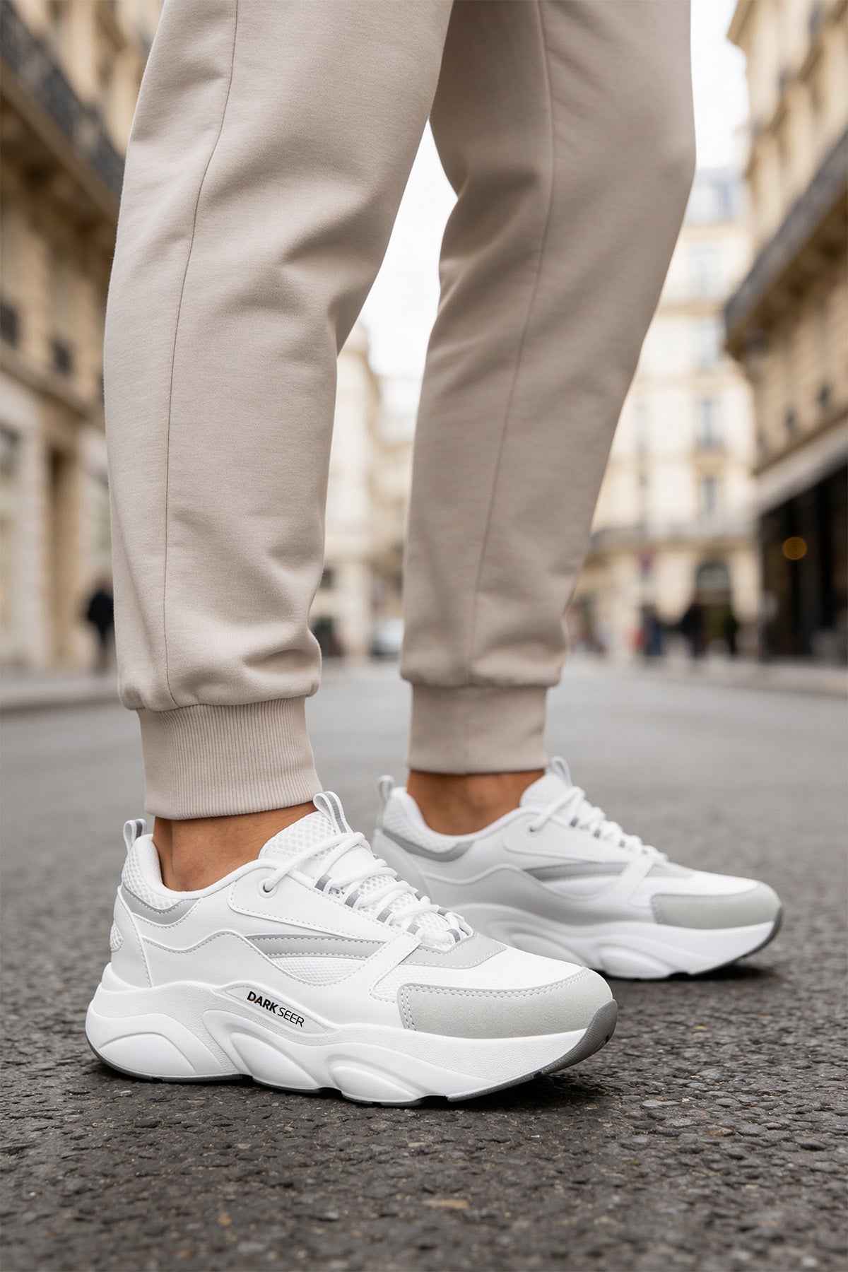 White chunky sneakers with lace-up front and textured rubber sole.