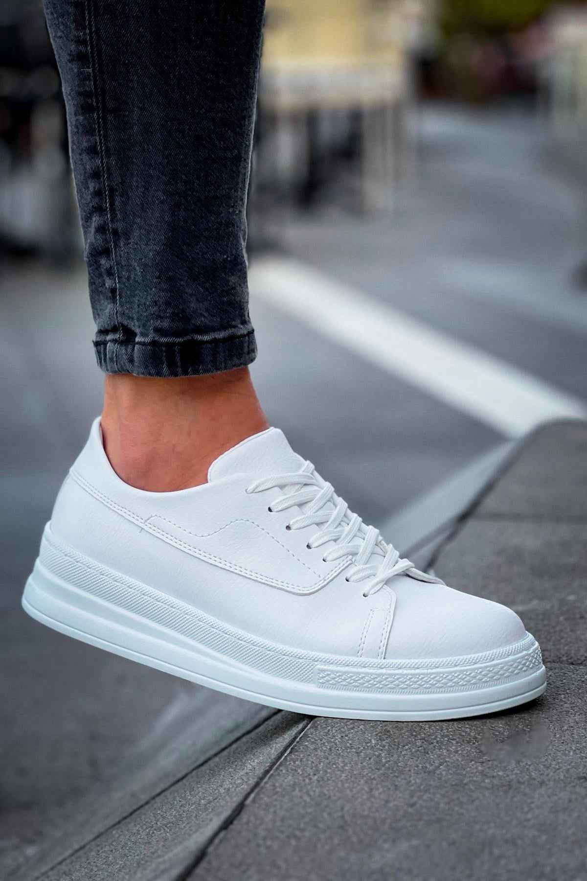 White lace-up sneakers with side panel stitching and thick sole