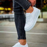 White lace-up sneakers with perforated toe and flat rubber sole