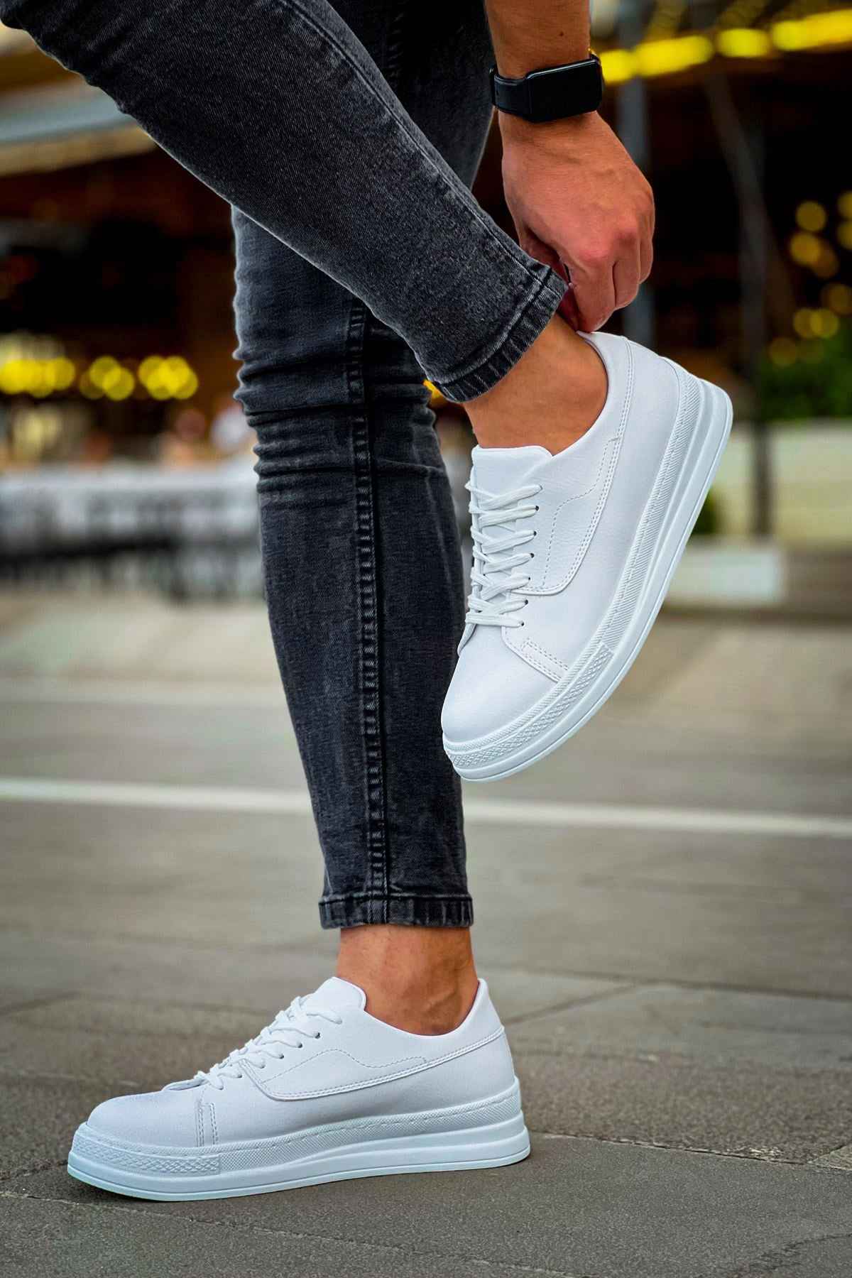 White lace-up sneakers with perforated toe and flat rubber sole