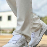 Men's white low-top sneakers with lace-up front and textured rubber sole