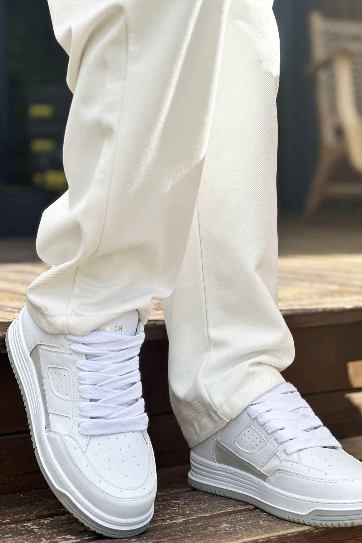 Men's white low-top sneakers with laces and side logo detail on steps