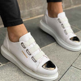 Men's white sneakers, side view with buckled strap and dark oval detail