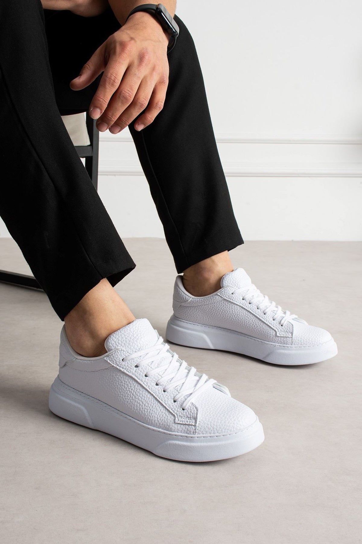 White lace-up low-top sneakers with textured upper and rubber sole