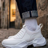 White sneakers with ribbed knit sock collar, lace-less design, and chunky sole