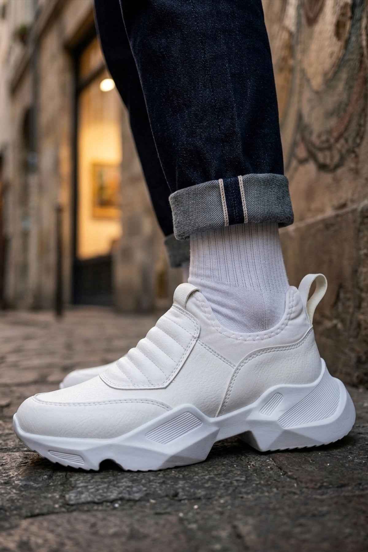 White sneakers with ribbed knit sock collar, lace-less design, and chunky sole