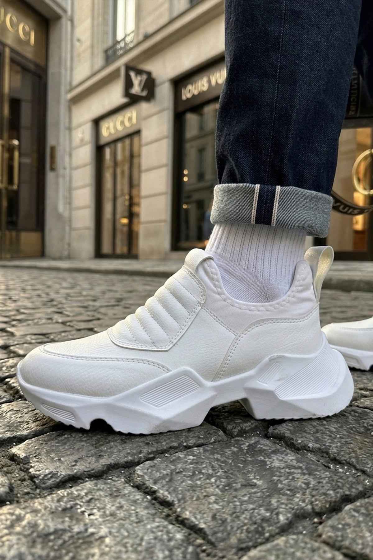 White sneakers with ribbed knit collar and thick tread sole, front 3/4 view