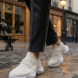 Men's white sneakers with lace-up style and chunky rubber sole with ribbed socks