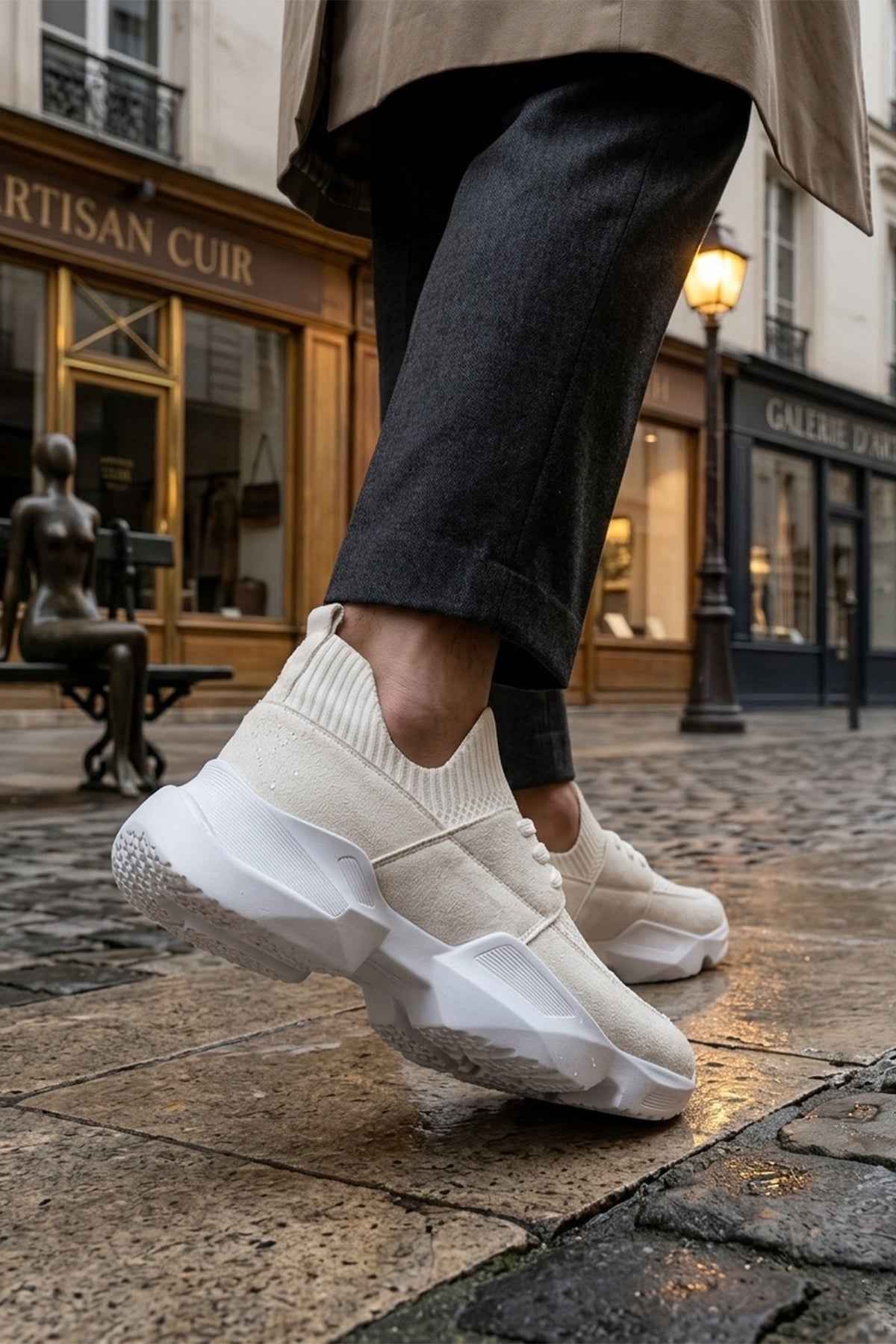 Men's white sneakers with textured upper and chunky sole, side profile on pavement