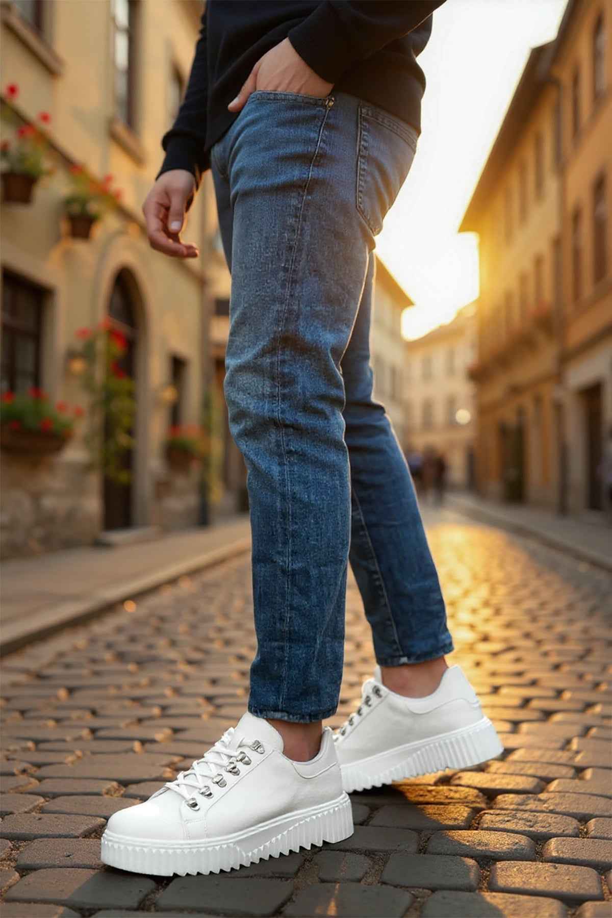 White low-top sneakers with lace-up front, worn with blue jeans