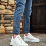 White low-top sneakers with lace-up front, worn with blue jeans