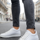 Men's white low-top sneakers with lace-up front, side view.