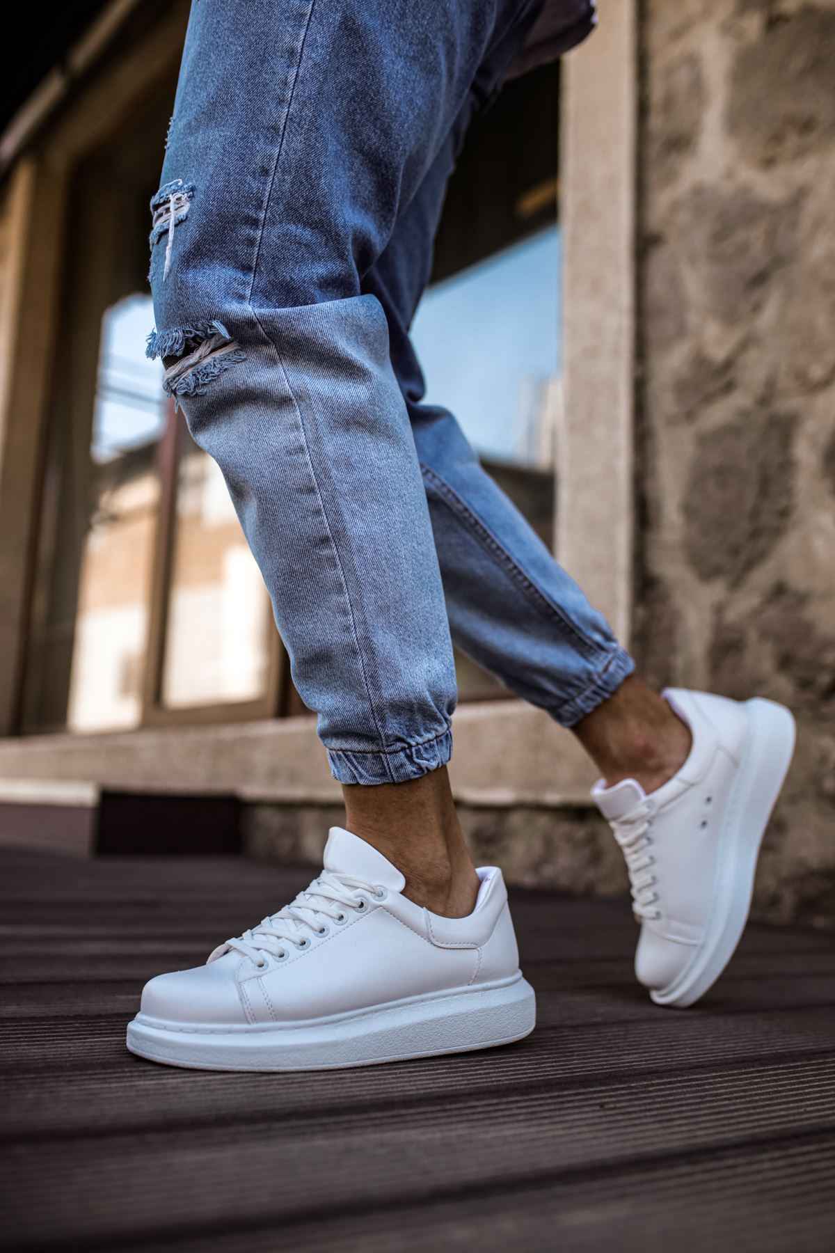 White low-top sneakers on wooden steps, lace-up with smooth upper