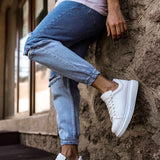 White low-top sneakers with white laces and thick rubber sole