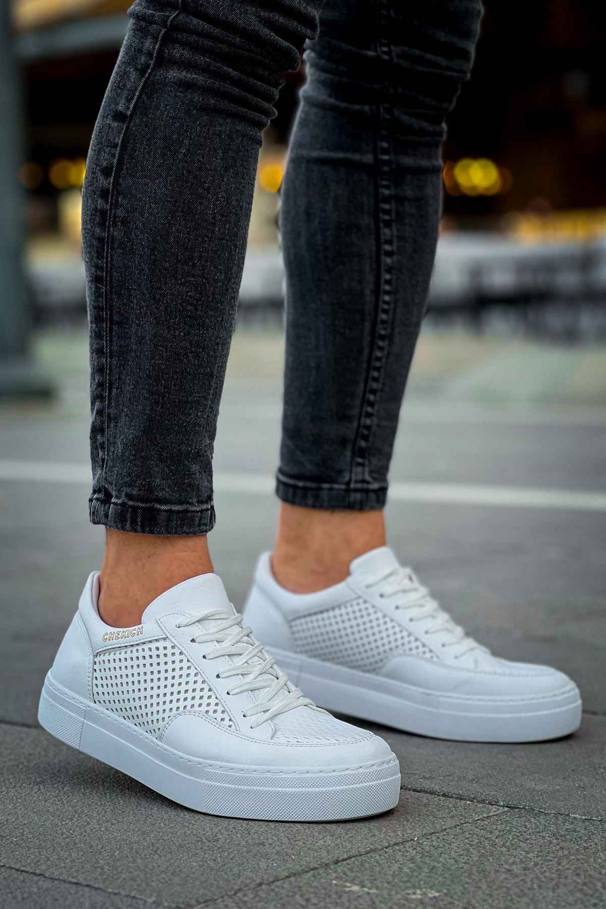 White lace-up sneakers with perforated side panels and white rubber sole