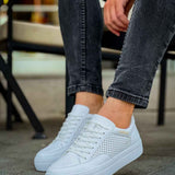 White lace-up sneakers, perforated uppers, and low-profile rubber sole