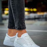 White sneakers with perforated sides and lace-up front