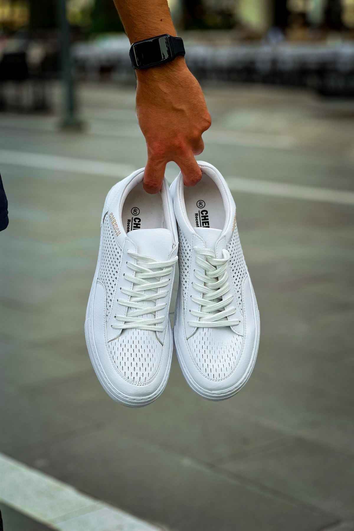 White sneakers shown from back, lace-up with perforated panels