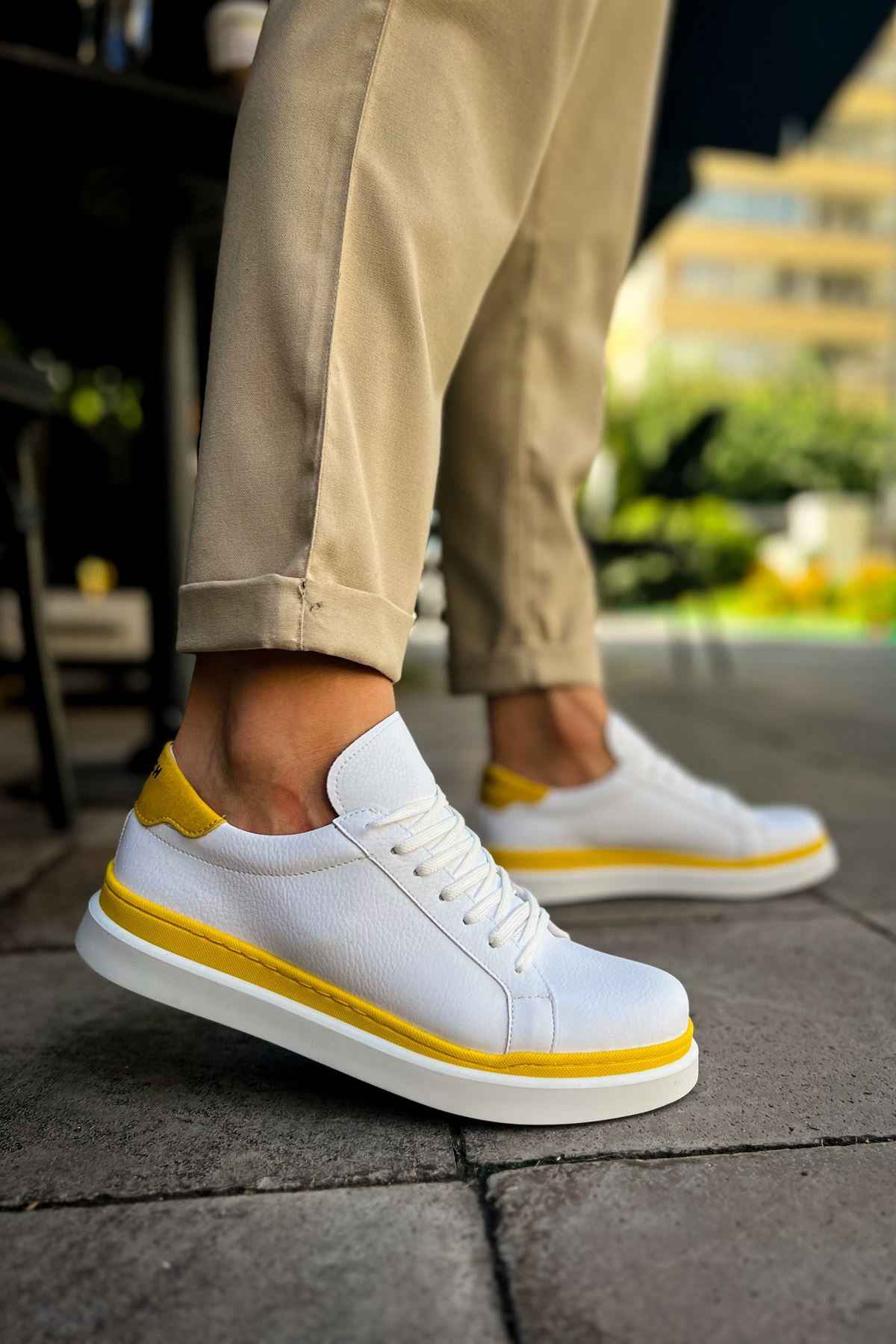 Men's white low-top sneakers with yellow trim and lace-up design