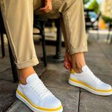 Men's white sneakers with yellow trim, lace-up front on low rubber sole