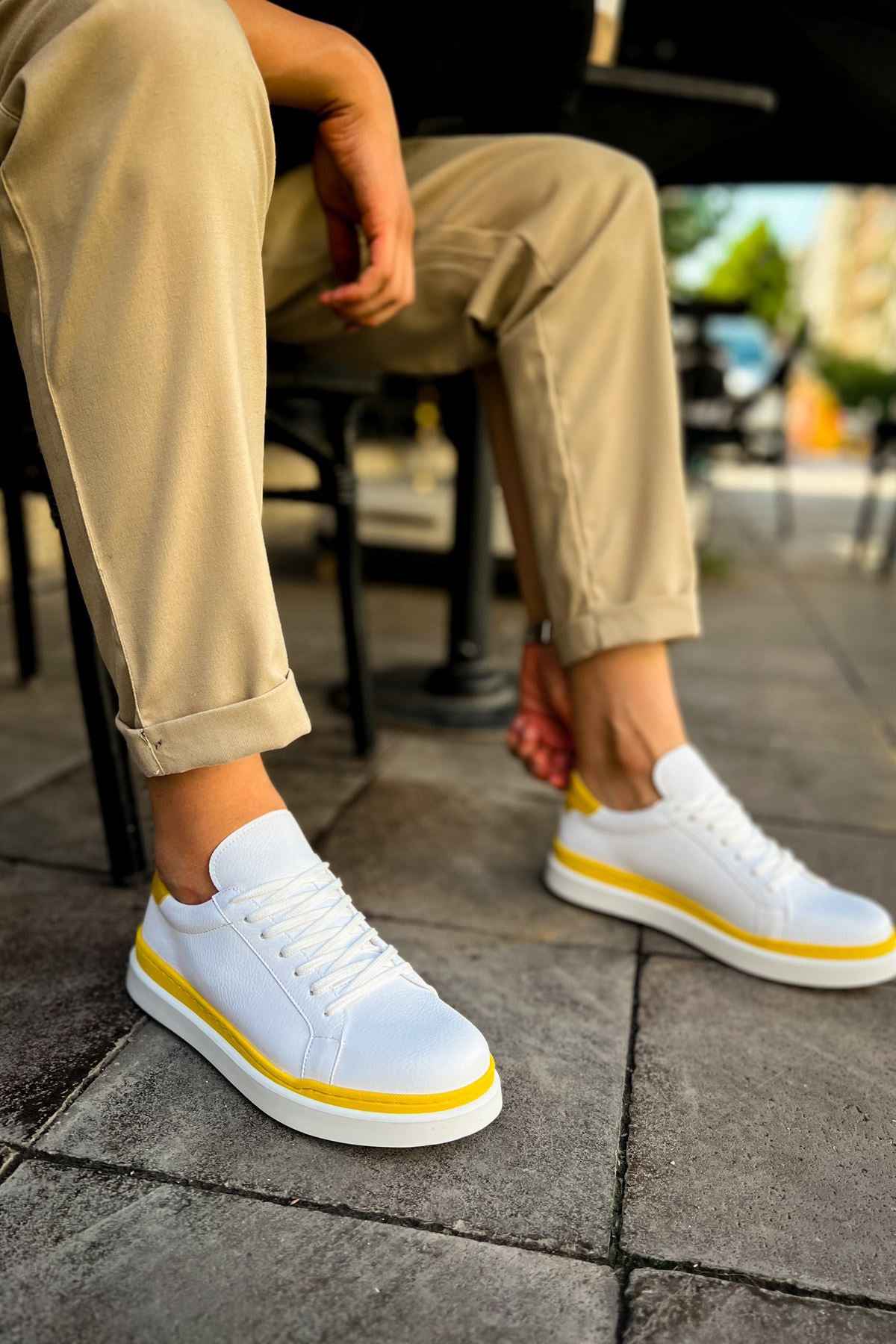 Men's white sneakers with yellow trim, lace-up front on low rubber sole