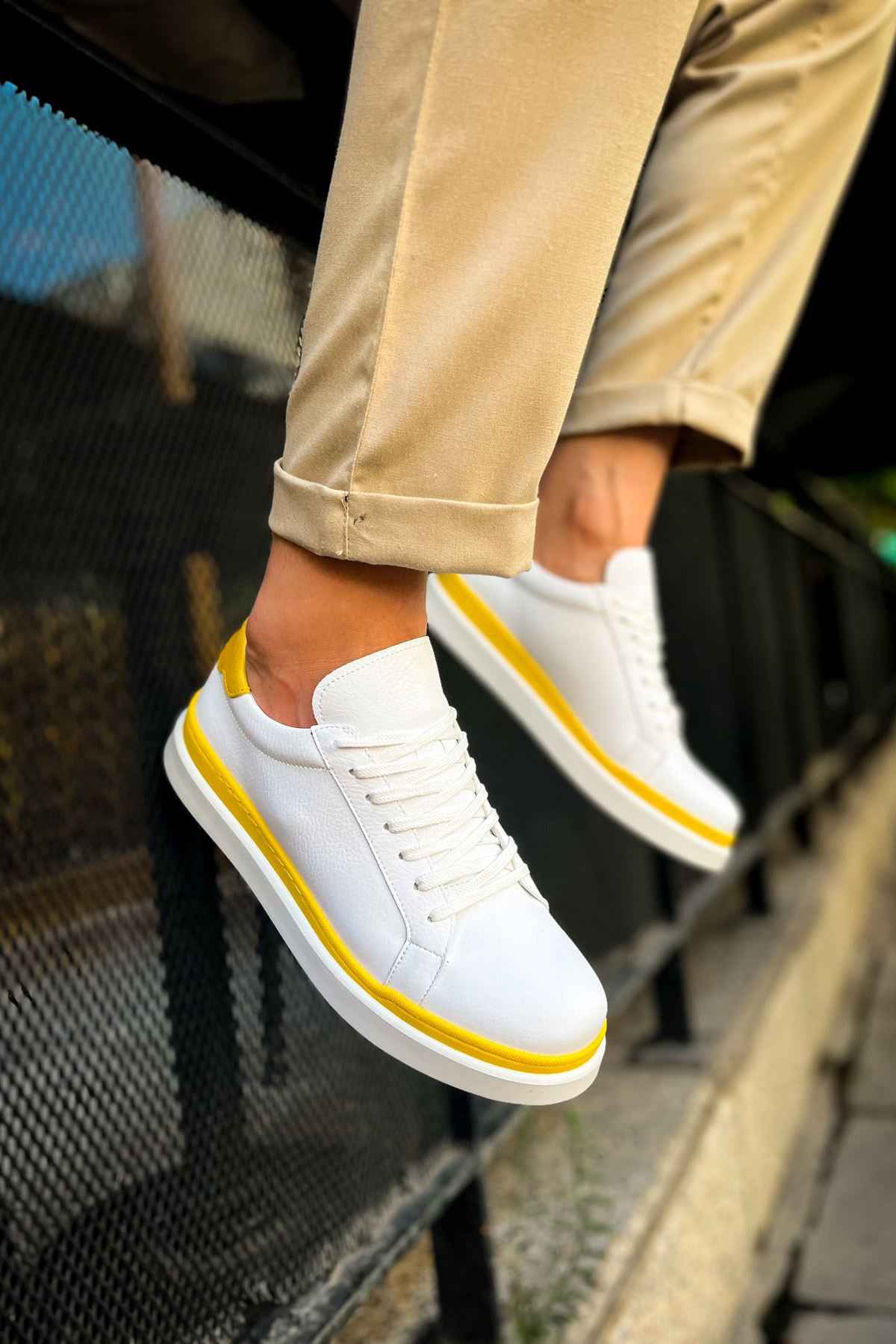 Men's white lace-up sneakers with yellow stripe, angled side view