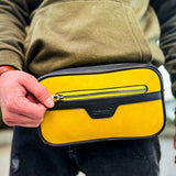 Men's yellow CH101 tablet bag with top zipper, held in hand