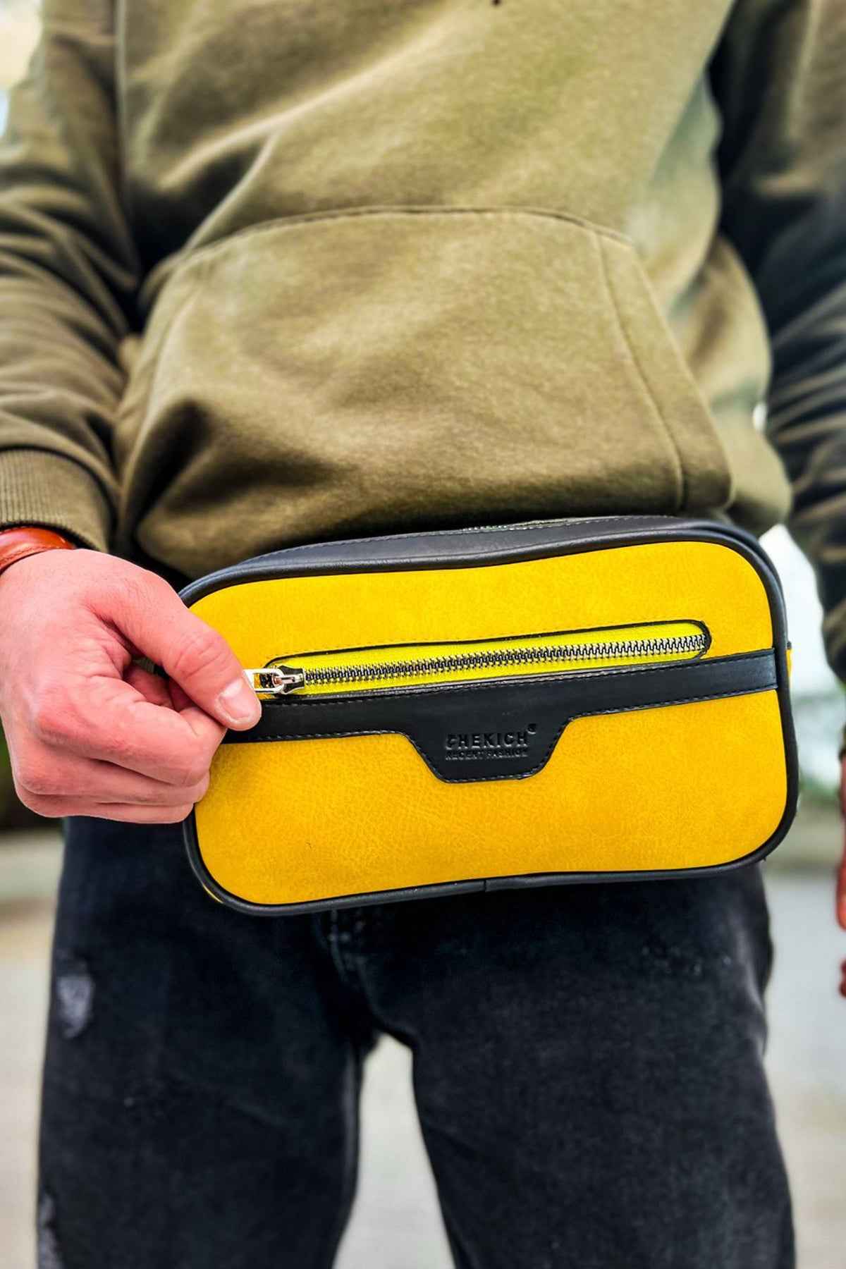 Men's yellow CH101 tablet bag with top zipper, held in hand