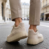 Beige suede sneakers, rear view with treaded rubber sole and lace-up detail